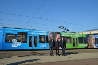 Das Bild zeigt Matthias Lux, René Walther und Vinzenz Schwarz vor der neuen Straßenbahn. Die drei Herren tragen funkle Kleidung und schauen in die Kamera.